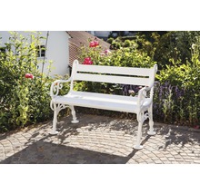 Weiße Gartenbank aus Metall vor Gartenkulisse