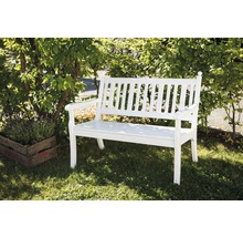 Weiße Gartenbank aus Holz neben einer Pflanze auf Rasen