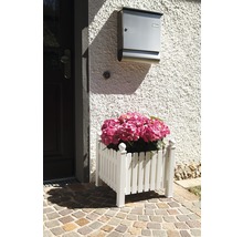Dekorativer Pflanzkasten aus Holz mit rosa Hortensien vor einer Haustür.