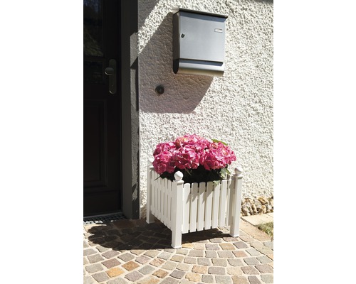 Dekorativer Pflanzkasten aus Holz mit rosa Hortensien vor einer Haustür.