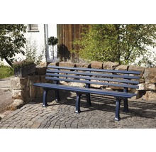 Gartenbank aus Metall vor Steinmauer und Pflastersteinen