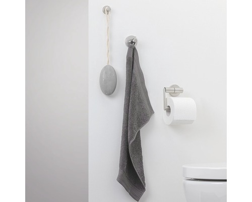 Badezimmerwand mit Handtuch, Bimsstein und Toilettenpapierhalter