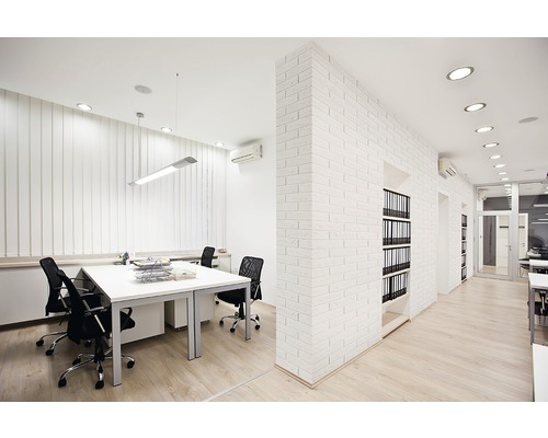 Helles Büro mit Schreibtischen, Bürostühlen, Beleuchtung und Regalen