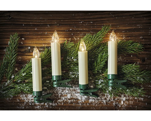 Vier kabellose LED-Christbaumkerzen mit grünen Klemmen und Tannenzweigen