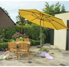 Gelber Sonnenschirm über Gartentisch und Stühlen im Garten