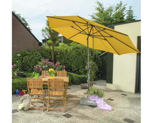 Gelber Sonnenschirm über Gartentisch und Stühlen im Garten