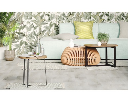 Wohnzimmer mit Sofa, Couchtischen und Pflanzen vor einer gemusterten Tapete