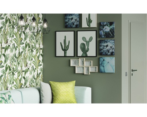 Wohnzimmer mit tropischer Tapete, Kaktusbildern und geometrischen Lampen