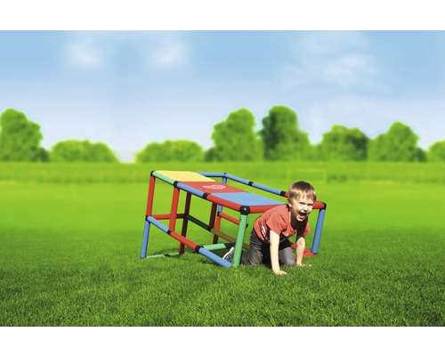 Junge kriecht unter einem bunten Klettergerüst im Garten