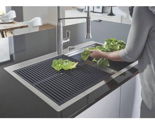 Edelstahlspüle mit Abtropfgitter und Salat im Küchenbereich