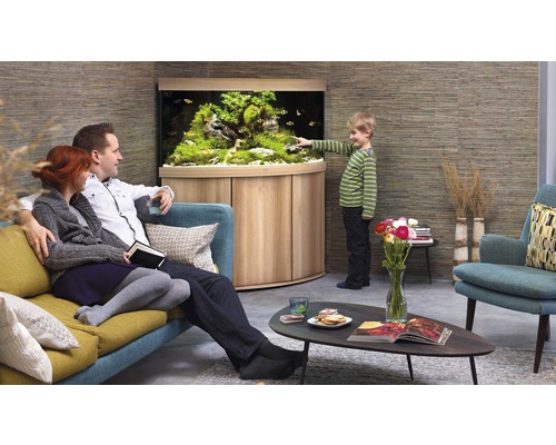 Familie betrachtet Aquarium im Wohnzimmer