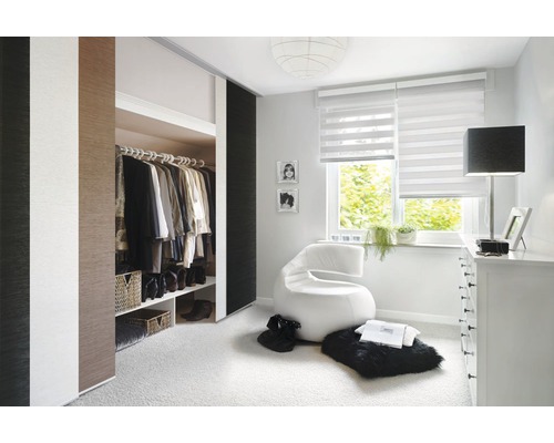 Helles Schlafzimmer mit Schiebetürenschrank, Rollo und modernem Sessel