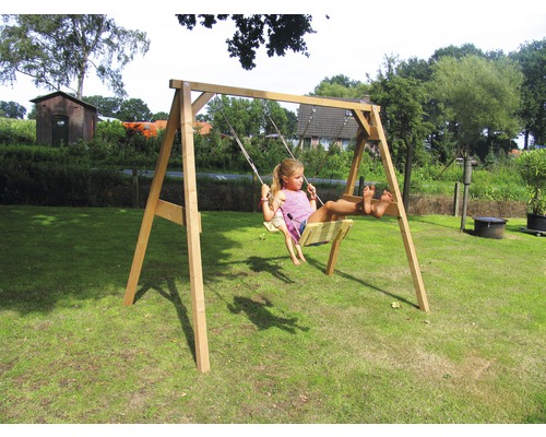 Holzschaukel mit schaukelndem Kind im Garten.