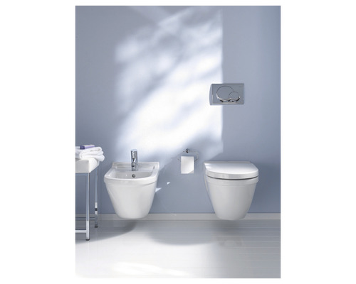 Badezimmer mit Wand-Bidet, Toilette, Spültaste und Handtüchern