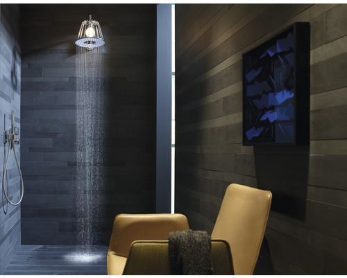 Badezimmer mit Dusche, Duschkopf, Fliesenwand, Stuhl und Kunstwerk