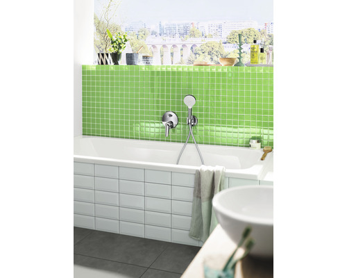 Modernes Badezimmer mit Badewanne, grünen Mosaikfliesen und Fenster mit Stadtblick