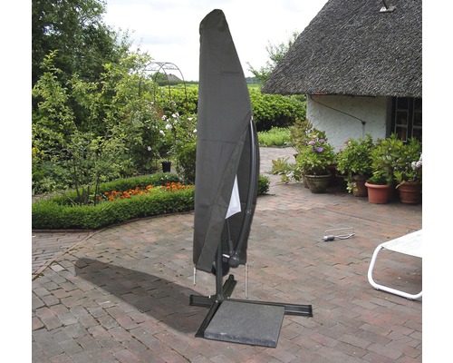 Abgedeckter Sonnenschirm auf einer Terrasse mit Garten im Hintergrund