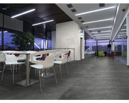 Innenraum mit Sitzgelegenheiten, Tischen und großformatigen Bodenfliesen für ein modernes Ambiente.