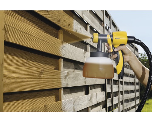 Farbsprühgerät im Einsatz auf einem Holzzaun