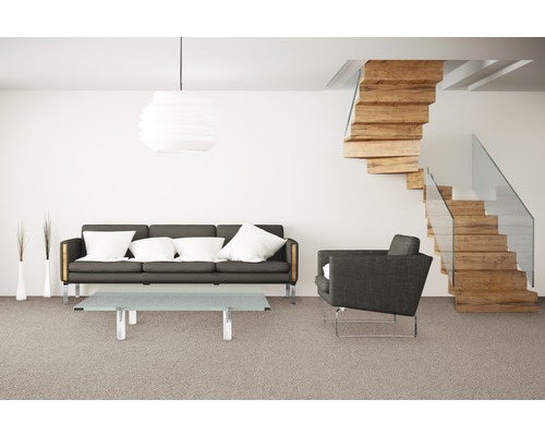 Wohnzimmer mit Sofa, Sessel, Tisch, Lampe und Holztreppe