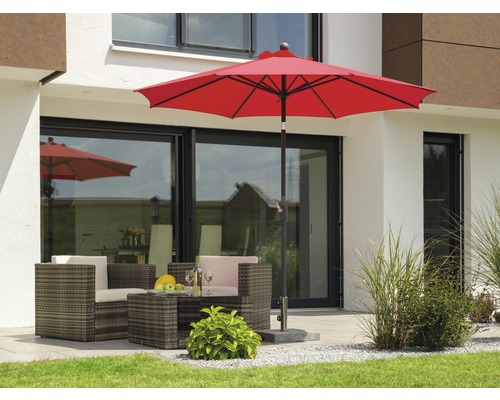 Terrasse mit rotem Sonnenschirm und Sitzgruppe aus Polyrattan