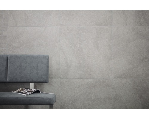 Wandgestaltung mit großformatigen, grauen Fliesen und Sitzbank