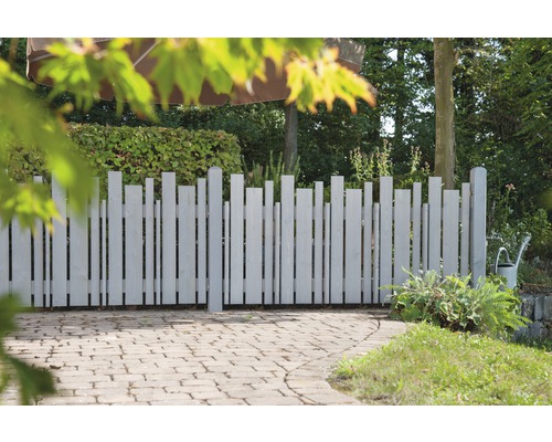 Holzzaun mit vertikalen Latten unterschiedlicher Höhe im Garten