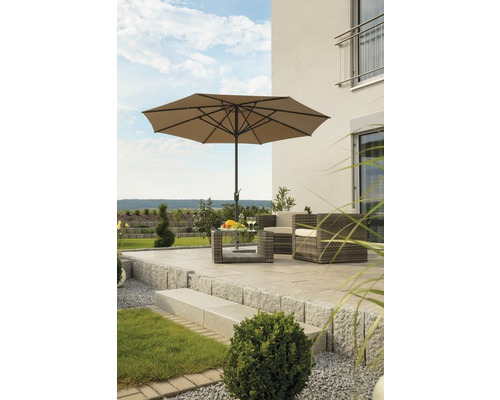 Terrasse mit Sonnenschirm, Rattansesseln und Tisch mit Obstschale