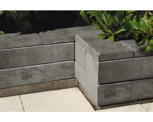 Detailaufnahme einer Gartengestaltung mit grauen Betonsteinen und Pflanzen