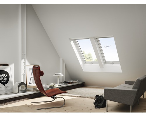 Helles Dachzimmer mit Dachfenstern, Sessel und Couch