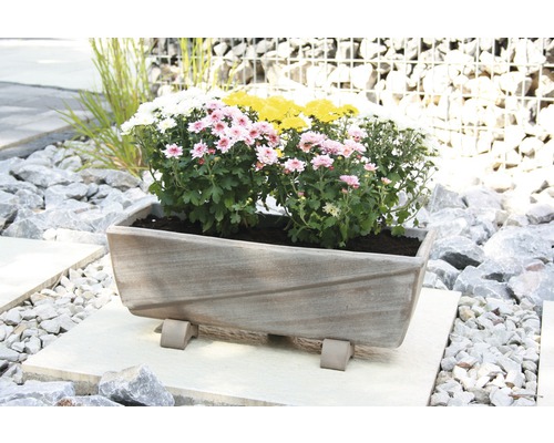 Rechteckiger Pflanzkübel mit Blumen auf einem Steinboden