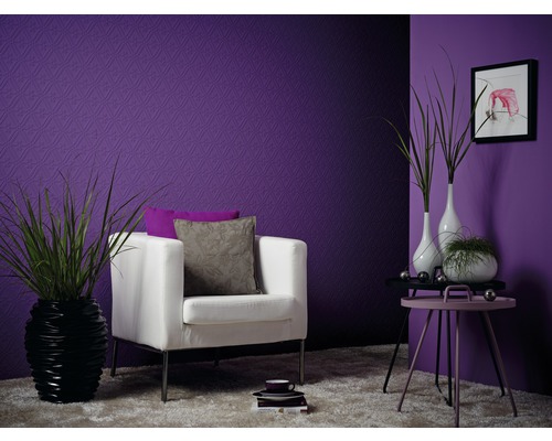 Dekoratives Wohnzimmer mit lila Tapete, Sessel, Beistelltisch und Zimmerpflanzen.