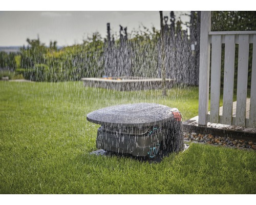 Rasenmähroboter im Einsatz bei Regen auf einer Rasenfläche.