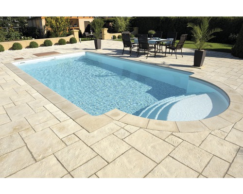 Schwimmbad mit Steintreppe und gepflasterter Umgebung im Garten