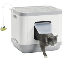 Katze verlässt eine Katzentoilette mit Spielzeugmaus