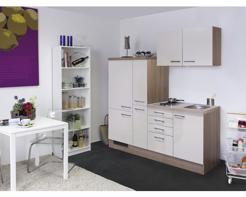 Küchenzeile mit Küchenschränken, Spüle, Herd, Regal, Tisch und Stuhl in einem Raum.