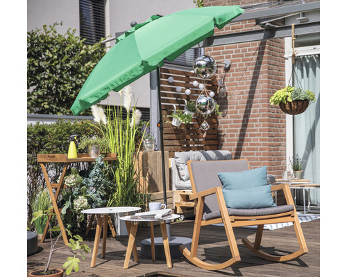 Terrassenszene mit Sonnenschirm, Holzschaukelstuhl, Beistelltischen und dekorativen Pflanzen