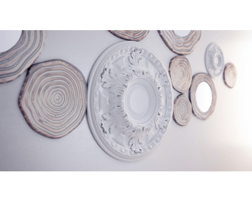 Wanddekoration mit Stuckrosette und Holzscheiben