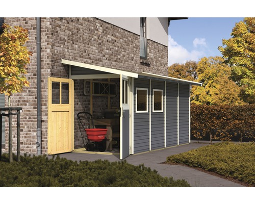 Gartenhaus Karibu Bernau inkl. Unterkonstruktion Fenster 181 x 355 cm terragrau Gartenhaus aus Holz mit geöffneter Tür und Fenstern neben einem Backsteingebäude