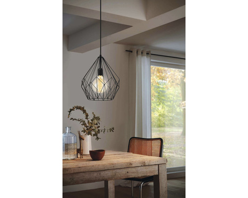 Esszimmer mit Holztisch und schwarzer Hängelampe im Drahtdesign