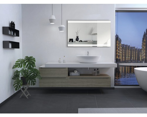 Modernes Badezimmer mit Waschtisch, Spiegel mit Beleuchtung, Pflanze und Badewanne