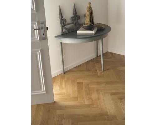 Eingangsbereich mit Fischgrätenparkett, Halbmondtisch und Dekoration