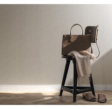 Interieuransicht mit gemusterter Tapete, Handtasche, Stuhl und Accessoires