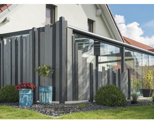 Holzzaun mit Pflanzenkübeln vor einem Haus