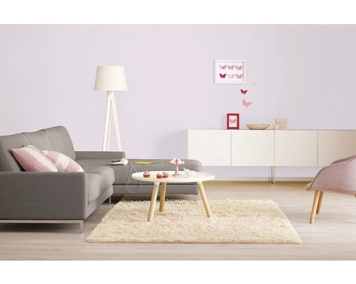 Wohnzimmer mit grauem Sofa, Teppich und weißen Möbeln für eine helle und organisierte Atmosphäre.