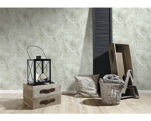 Dekorative Wohnrauminszenierung mit floral gemusterter Tapete, Laterne, Kissen, Holzboxen und Dekoelementen