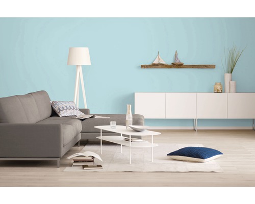 Wohnzimmer mit Sofa, Tisch, Lampe und Wandregal