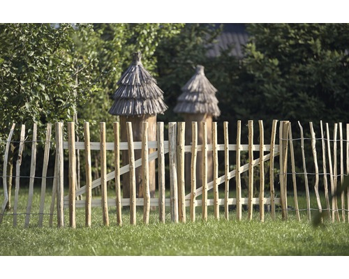 Gartenszene mit Holzzaun und zwei Bienenkörben