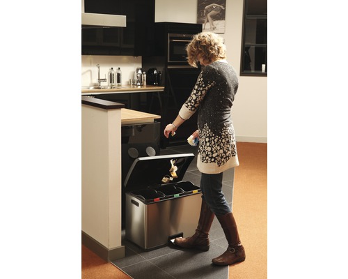 Frau benutzt einen Abfalltrennsystem Eimer in der Küche