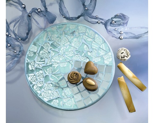 Dekorativer Mosaikteller mit Süßigkeiten und Dekoband